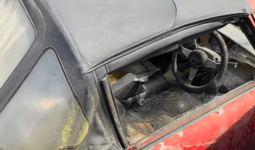 a red car with a black roof and a black steering wheel