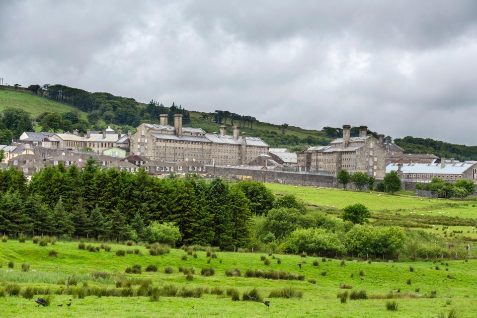 a large building sits in the middle of a grassy field