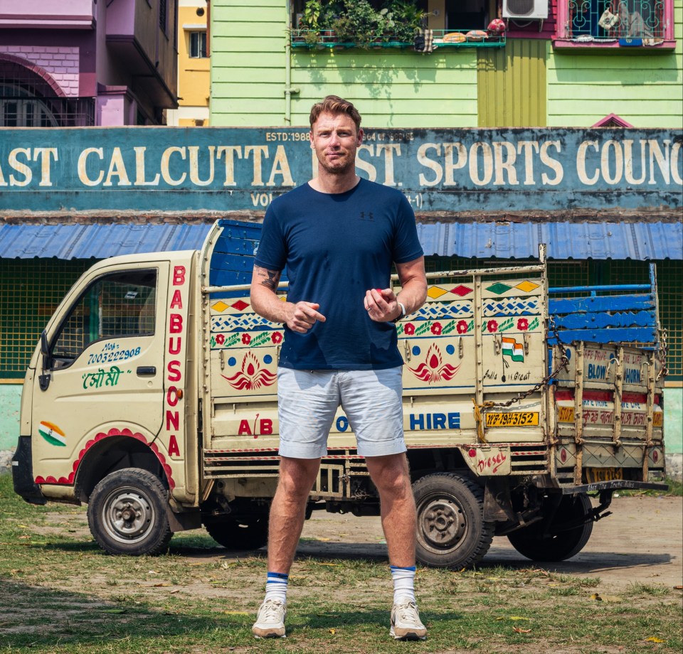 a man stands in front of a truck that says hire