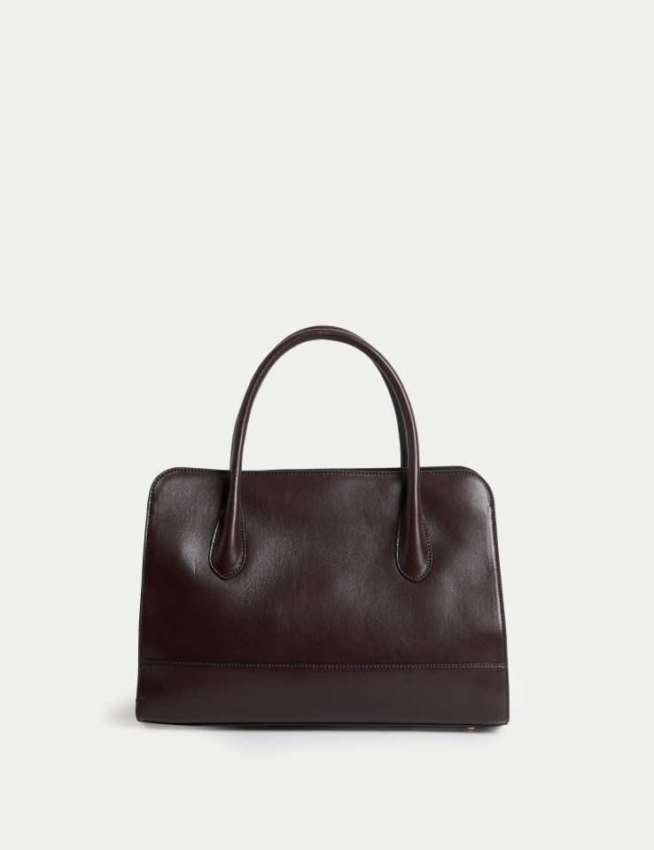 a brown leather bag with a handle on a white background