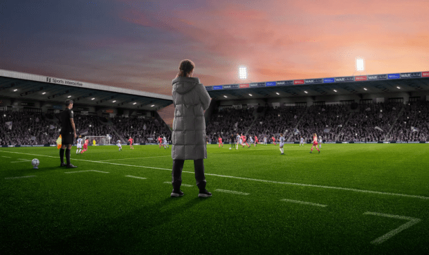 a woman watches a soccer game in a sports interactive stadium