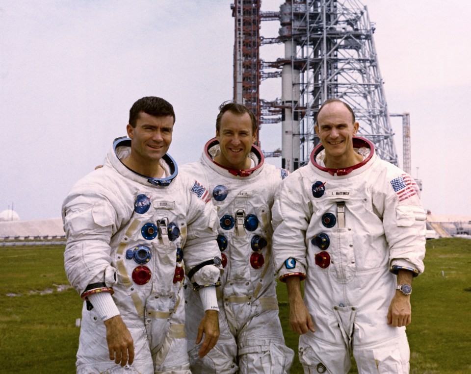 three nasa astronauts pose for a photo in front of a building