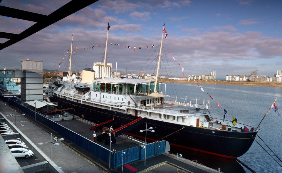 a large ship is docked in the water with flags on the masts