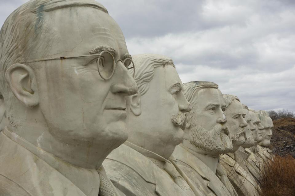 a row of statues of presidents are lined up in a row