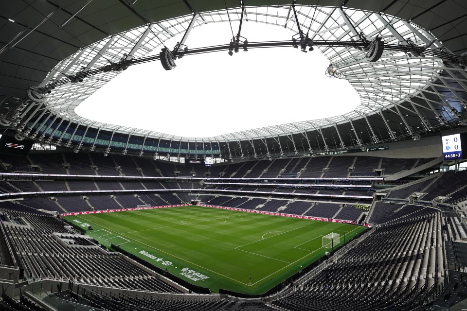 an empty soccer stadium with emirates written on the field