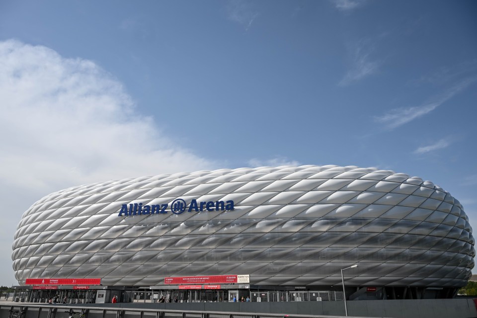 a large allianz arena with a blue sky in the background