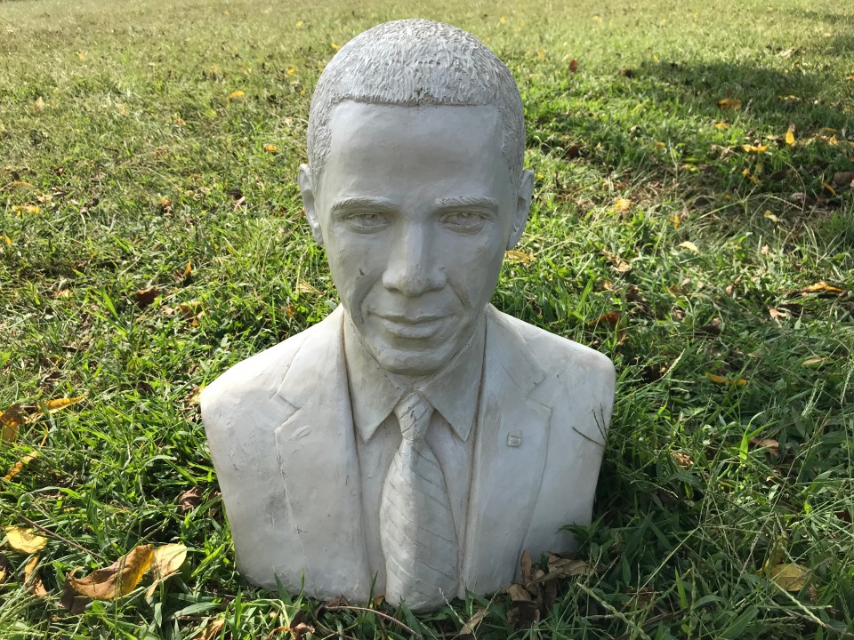 a statue of barack obama is sitting in the grass