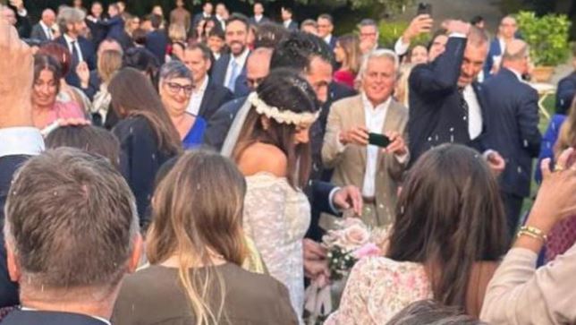 a bride and groom are walking through a crowd of people at a wedding .