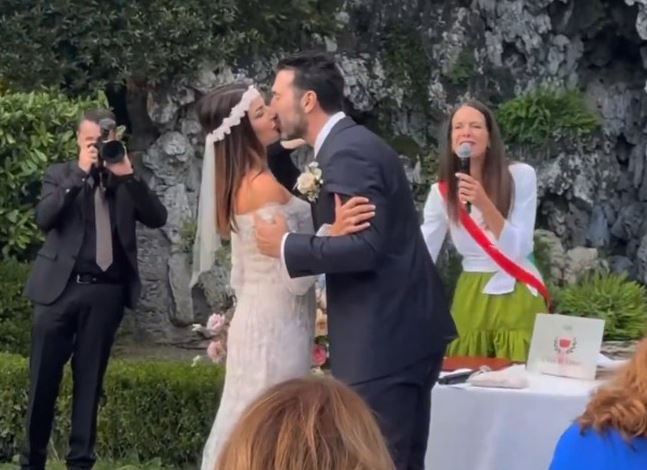 a bride and groom kiss during their wedding ceremony