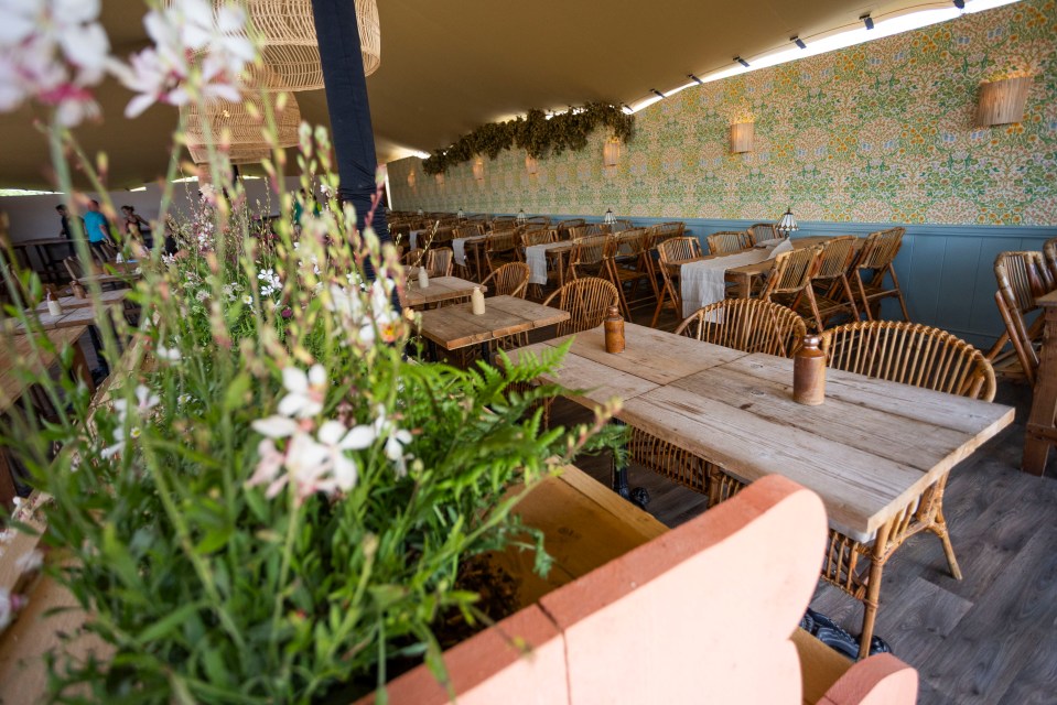 a restaurant with tables and chairs and flowers in the foreground