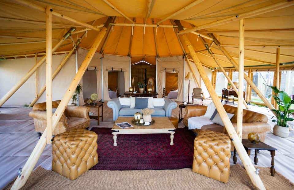 a living room in a tent with a couch and chairs