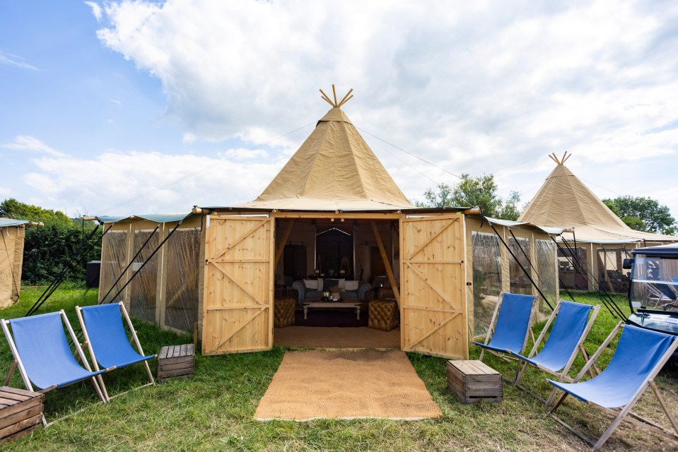 a row of blue chairs sit outside of a teepee