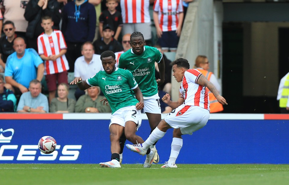 a soccer player wearing a green jersey that says classic builders