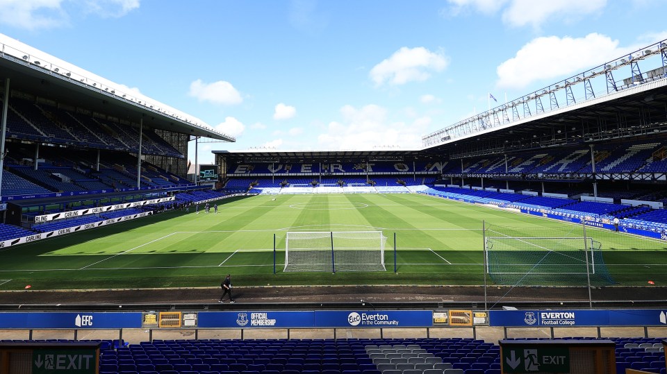 an empty everton stadium with a green exit sign