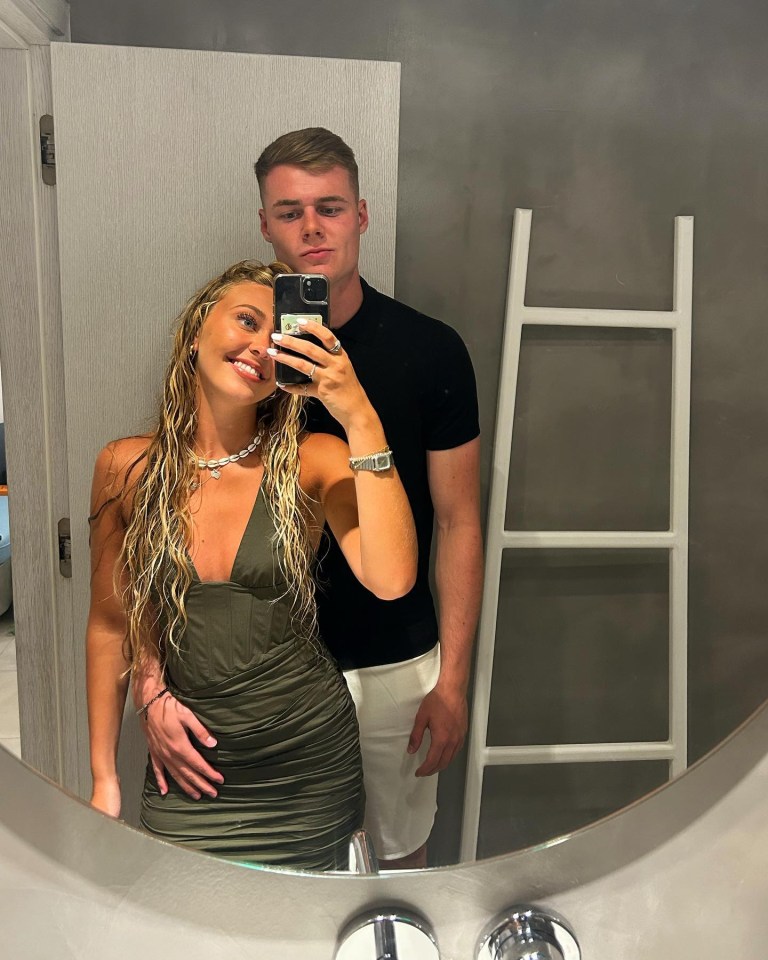 a man and a woman are taking a selfie in front of a mirror