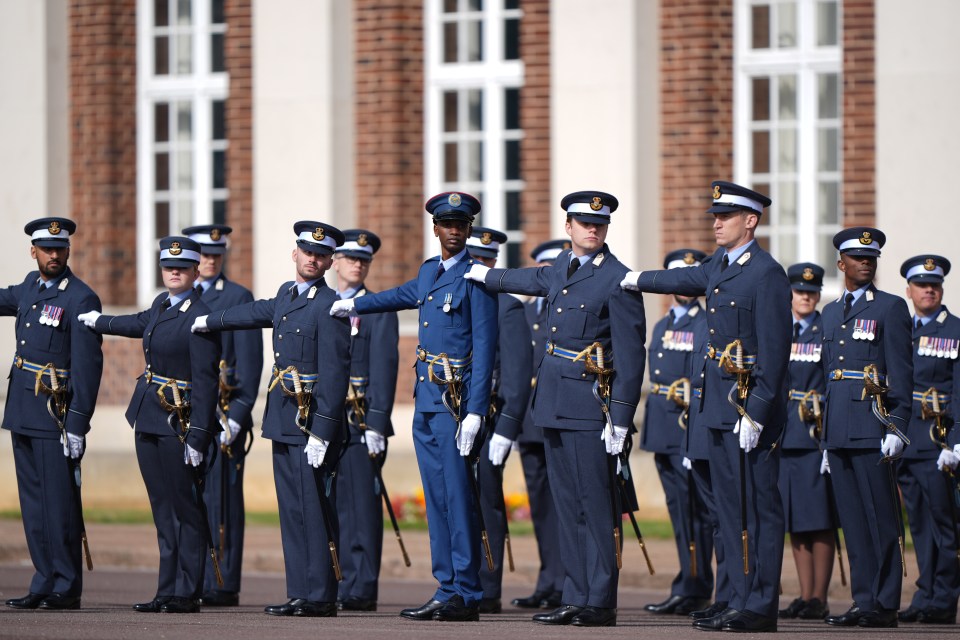 a group of men in military uniforms stand in front of a building