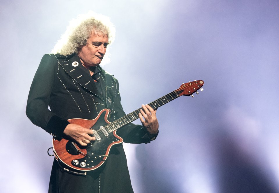 a man in a black jacket is playing a guitar