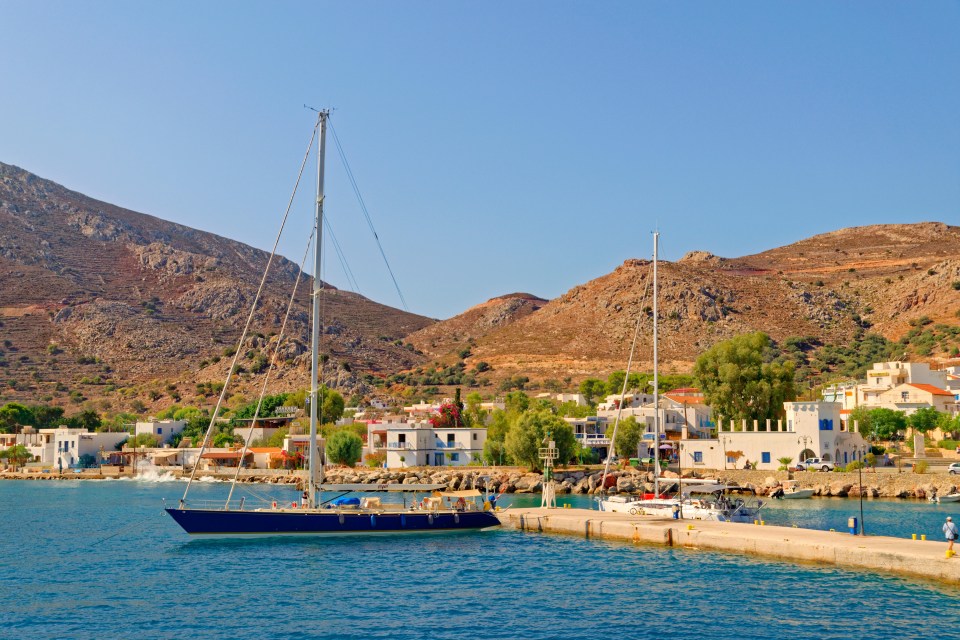 a boat is docked in a harbor with mountains in the background