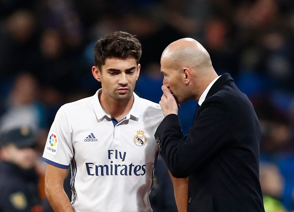 a man wearing a fly emirates shirt talks to another man