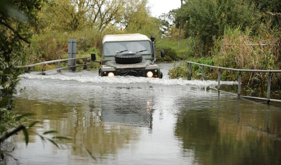 a military vehicle is driving through a flooded area