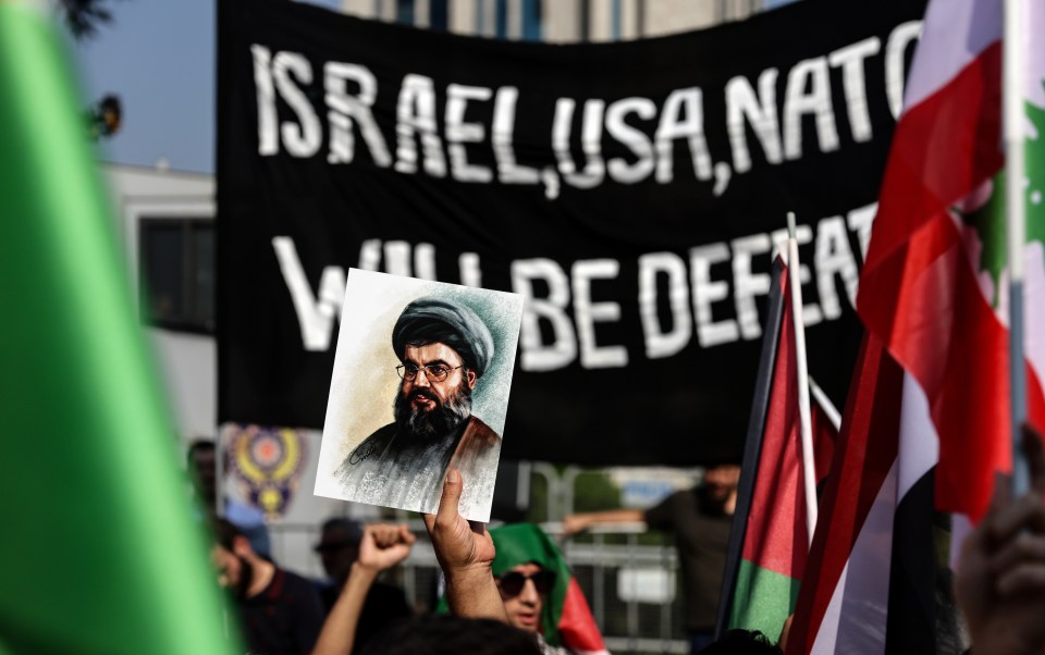 Protesters in Turkey holding up pictures of Nasrallah and a banner which says 'Israel, USA, Nato will be defeated'