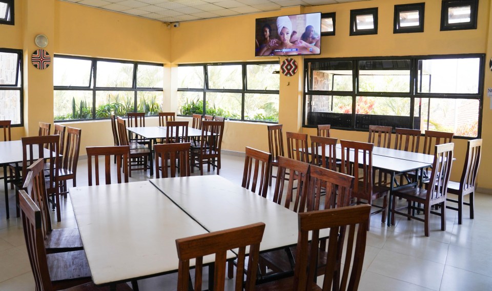 a dining room with tables and chairs and a tv on the wall