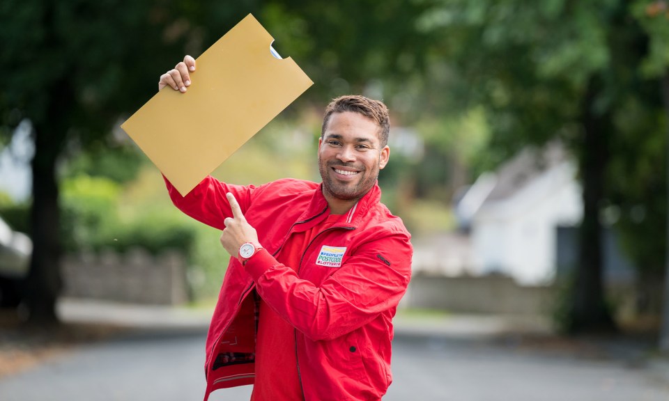 a man in a red jacket with a sticker on his jacket that says priority mail