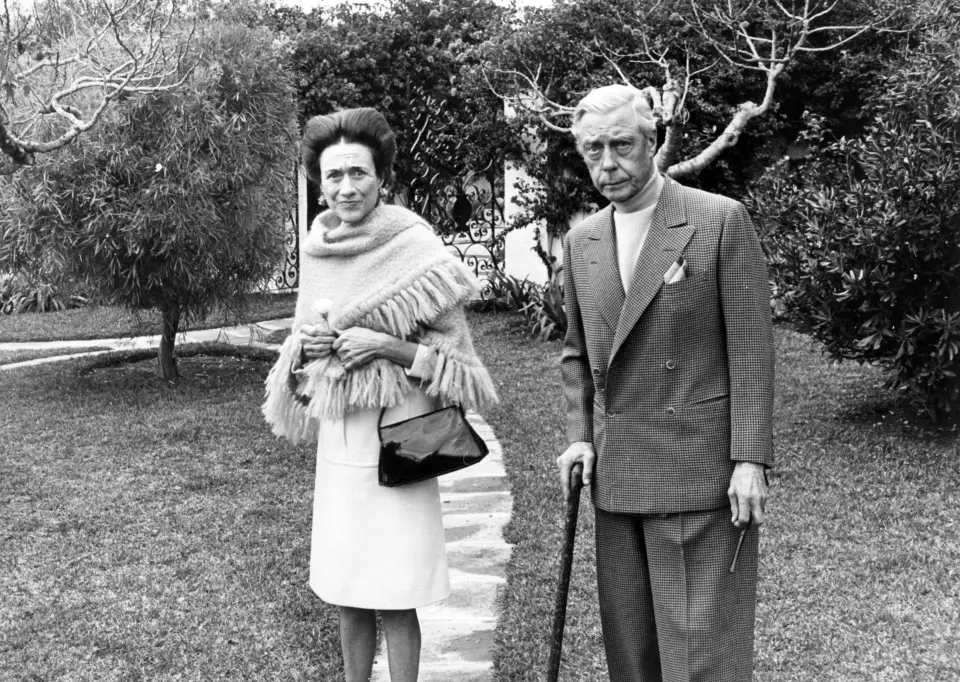 a black and white photo of a man and woman standing next to each other