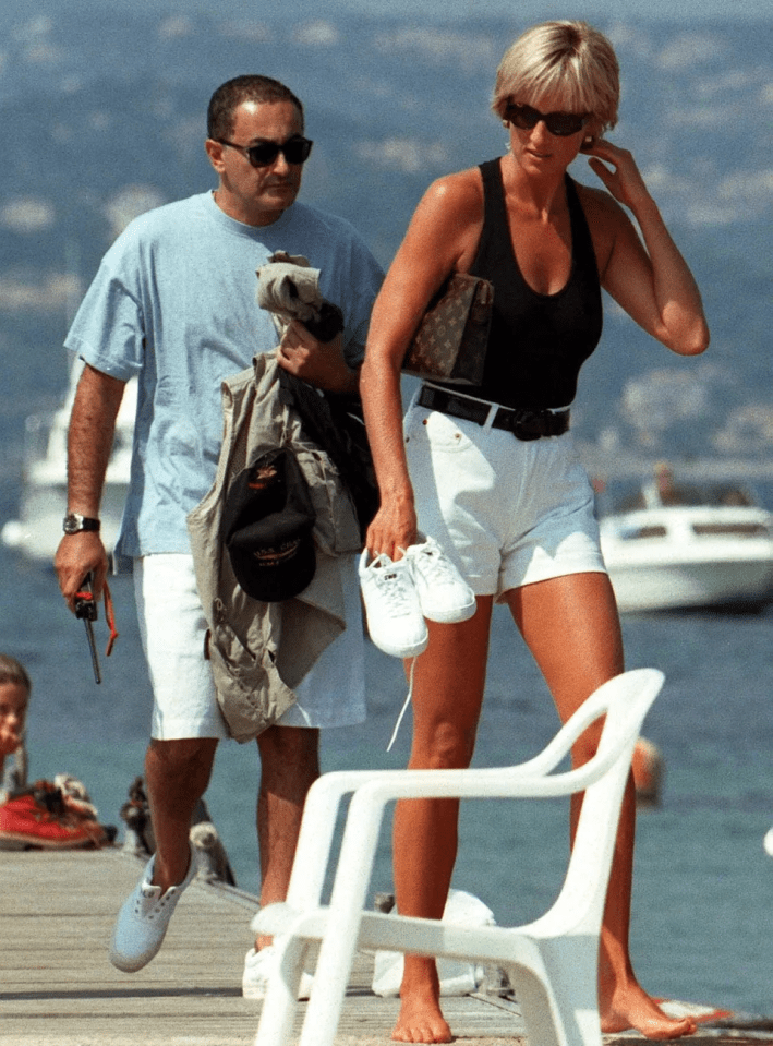 a woman in a black tank top and white shorts stands next to a man in a blue shirt