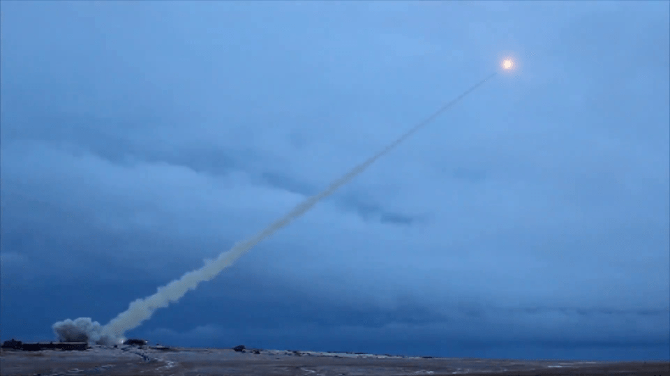 a rocket is flying through a cloudy blue sky