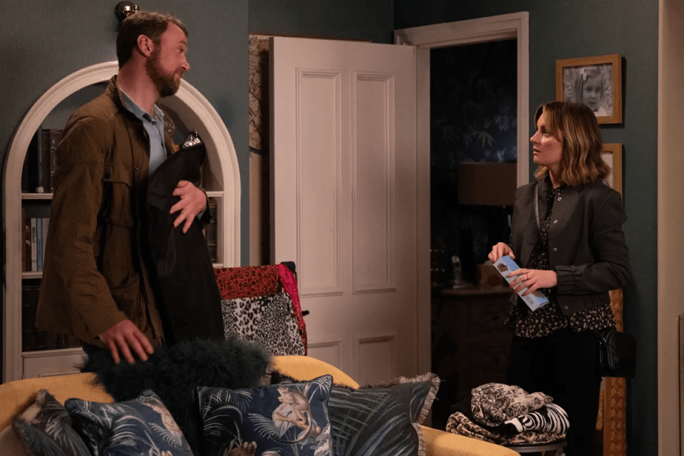 a man and a woman are standing next to each other in a living room