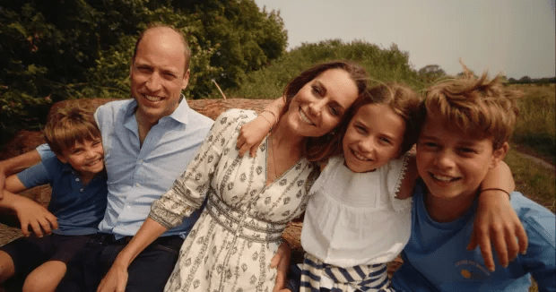 a family posing for a picture with a man wearing a blue shirt that says ' california ' on it