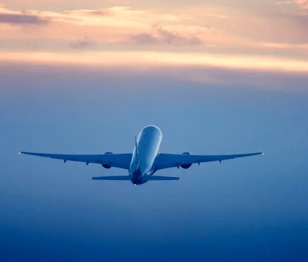 an airplane is flying through a cloudy blue sky