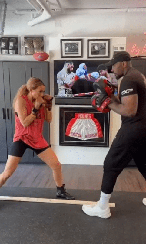 a man and a woman are boxing in front of a framed picture of holmes shorts