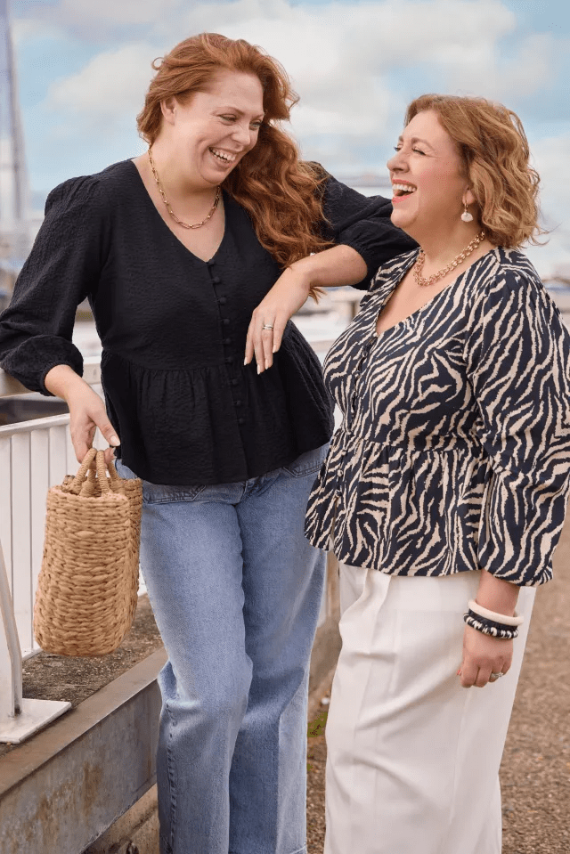 two women are standing next to each other and laughing