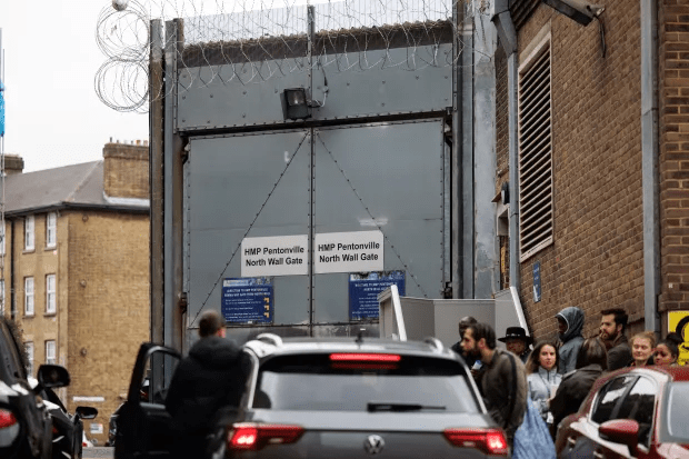 a group of people standing outside of a hmp pennsville north wall gate