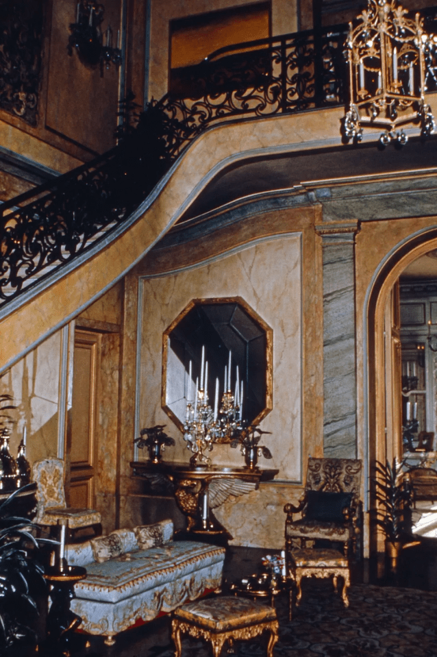 a living room with a staircase and a mirror