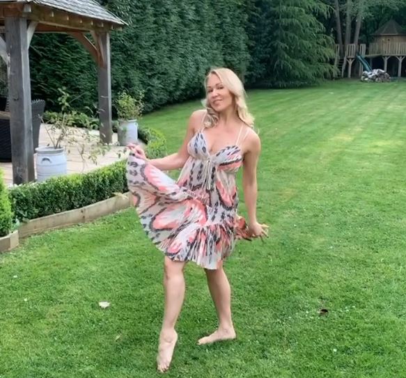 a woman in a dress is dancing in the grass .