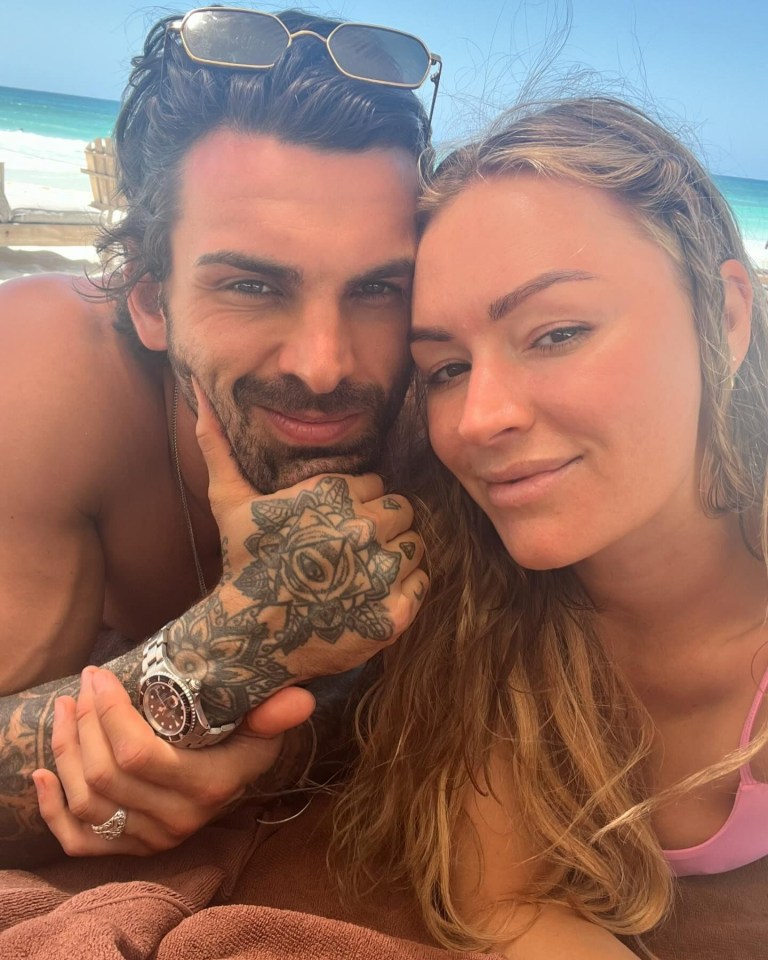 a man and a woman are posing for a picture on the beach