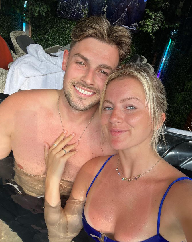 a man and a woman are posing for a picture in a hot tub