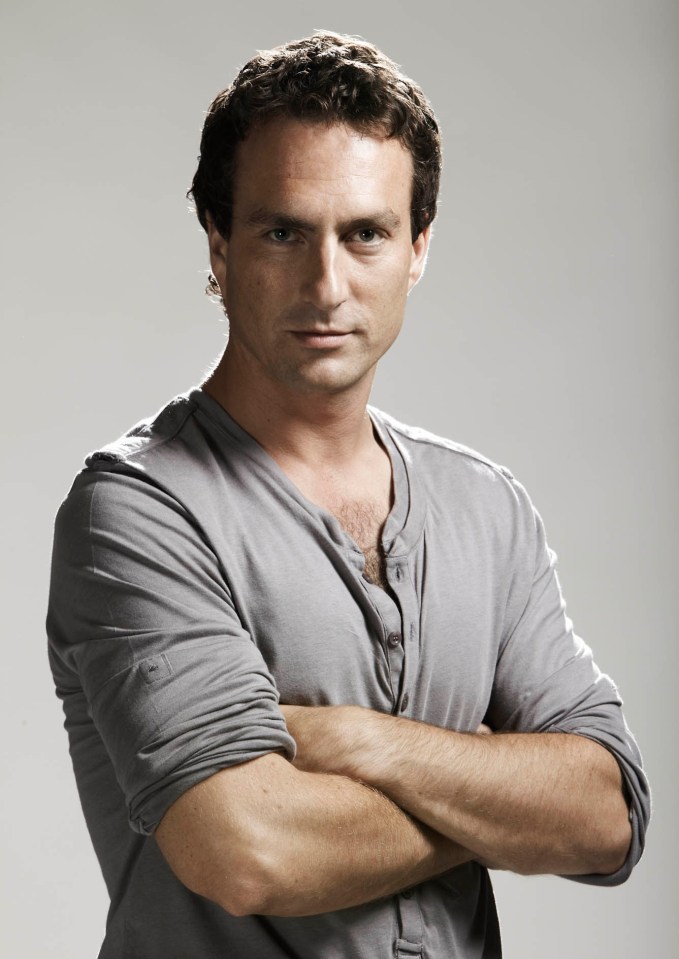 a man with his arms crossed is wearing a grey shirt