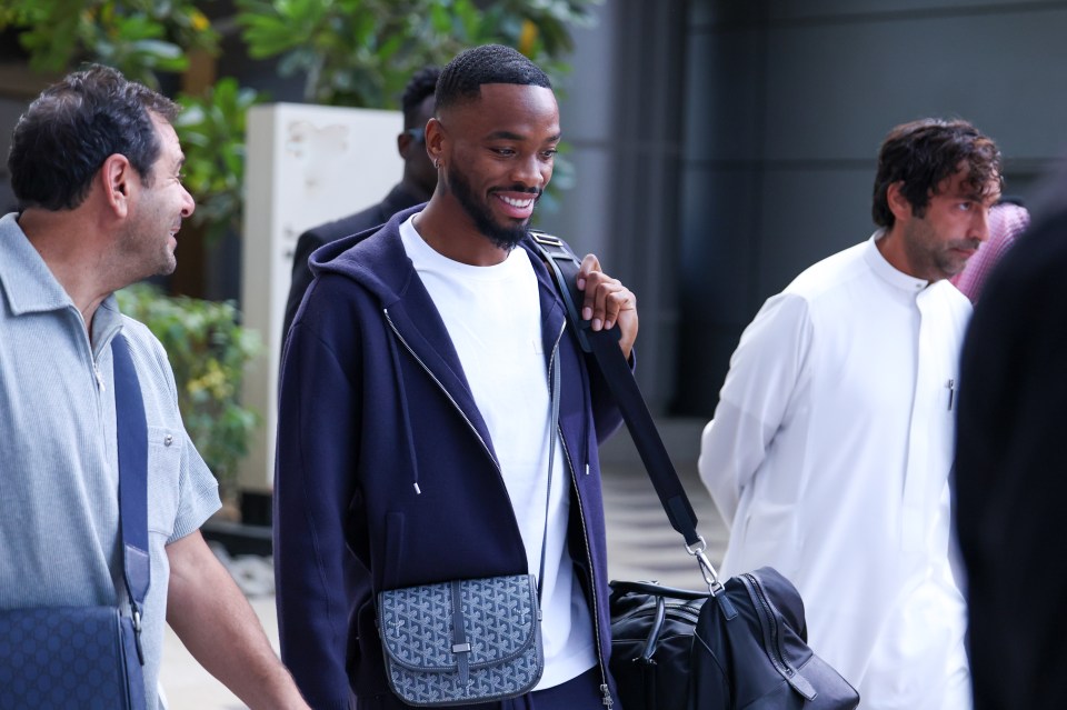 a man in a purple jacket carrying a bag that says ' louis vuitton ' on it