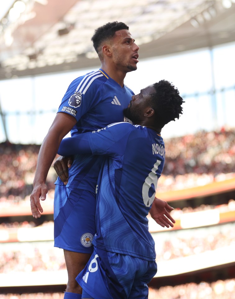 two soccer players are hugging and one has the number 6 on his jersey