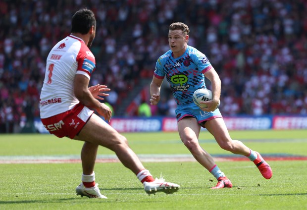 two rugby players on a field with one wearing a jersey that says gp