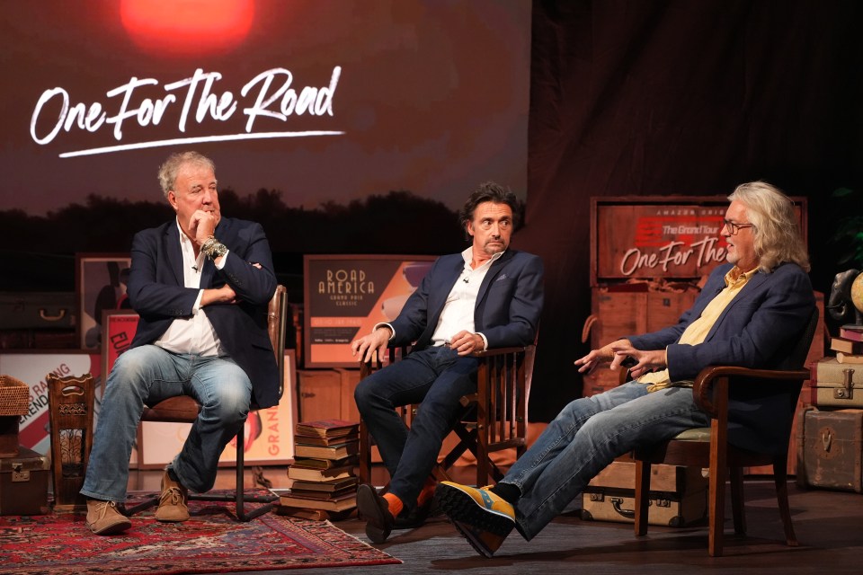 three men sit in front of a sign that says one for the road