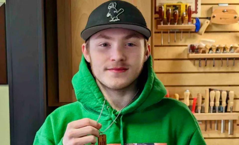 a man wearing a green hoodie and a hat with a beaver on it