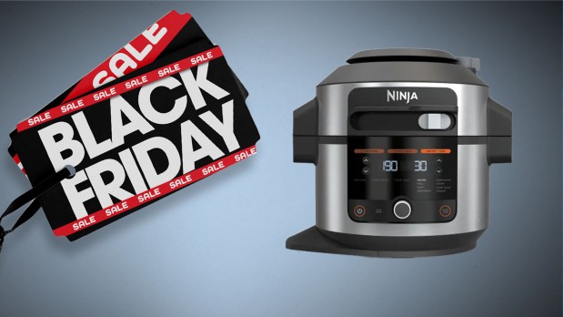 a ninja pressure cooker sits next to a black friday sale sign