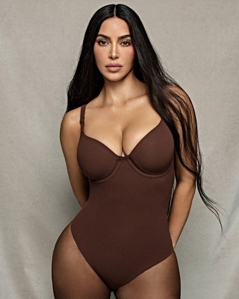 a woman with long hair is wearing a brown bodysuit