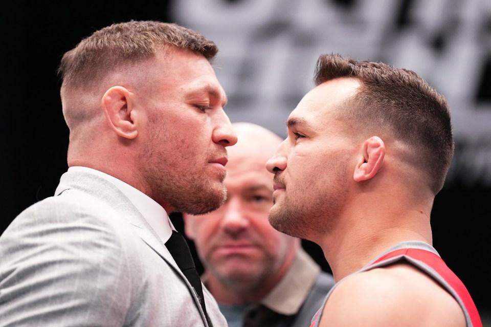 two men looking at each other with a referee in the background