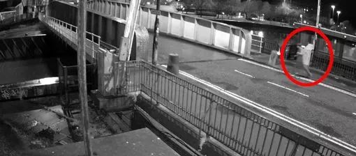 a black and white photo of a bridge with a red circle around it .